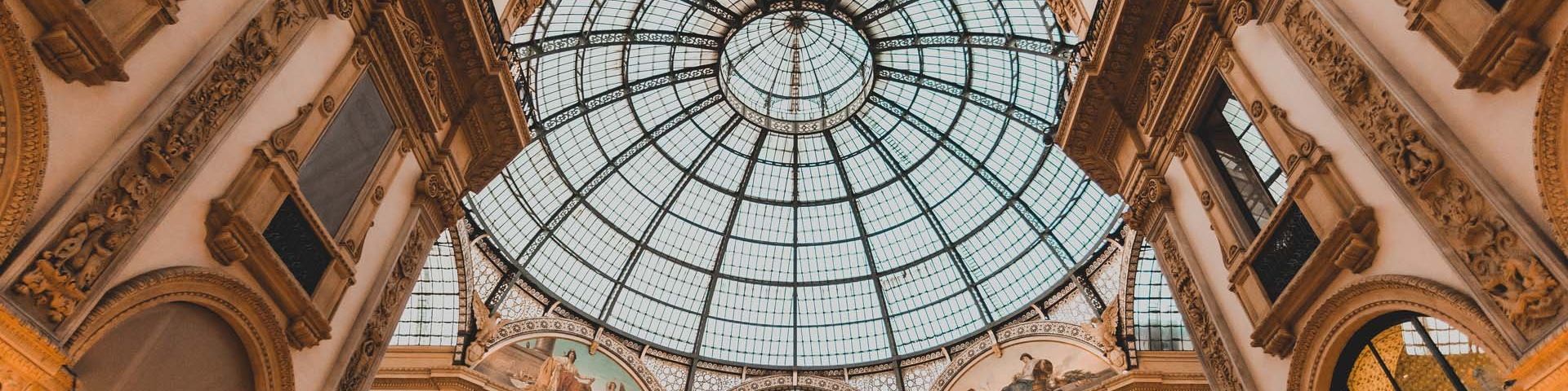An ornate building from the inside, with a glass domed ceiling